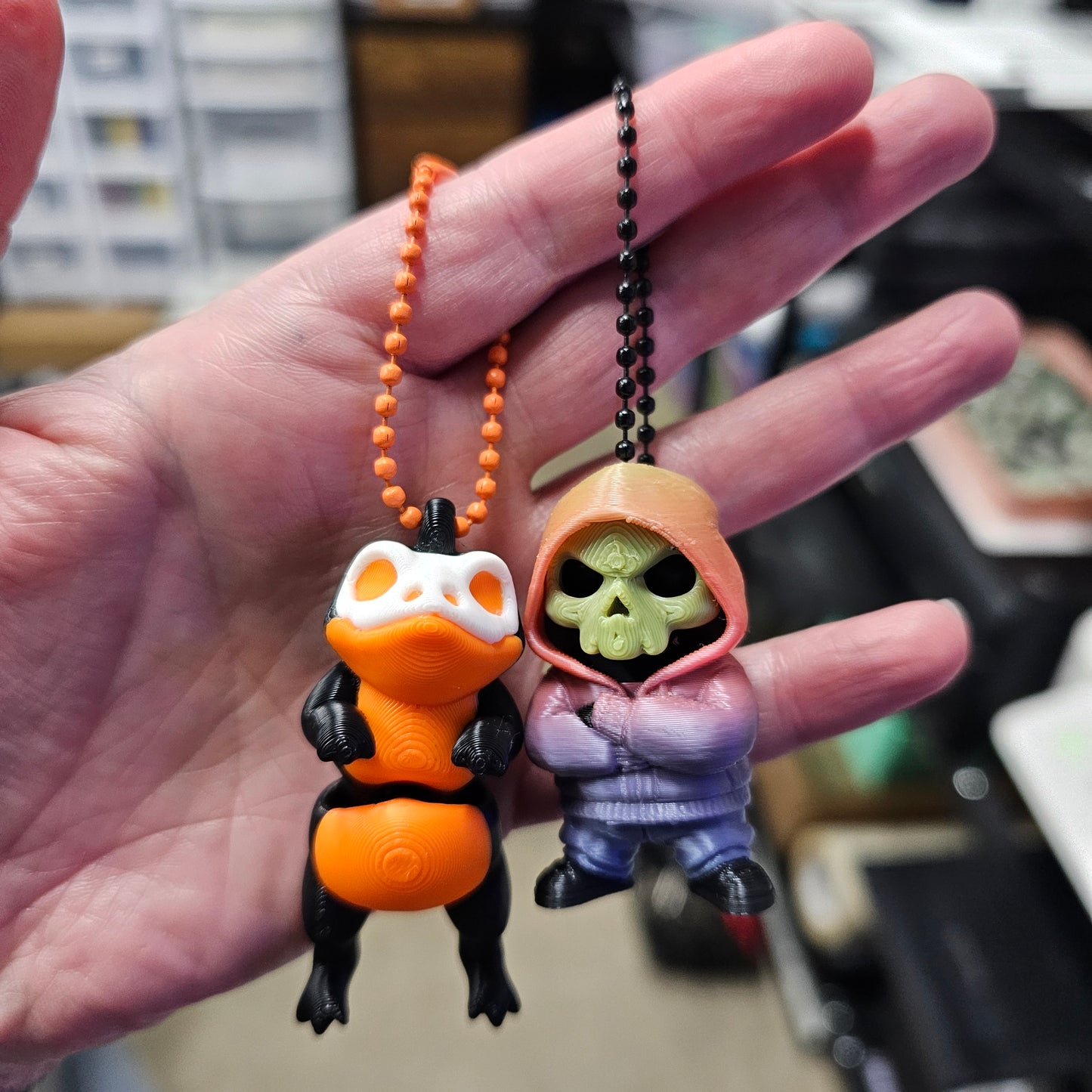 Hand holding a small toy figure with a colorful design, blurred background