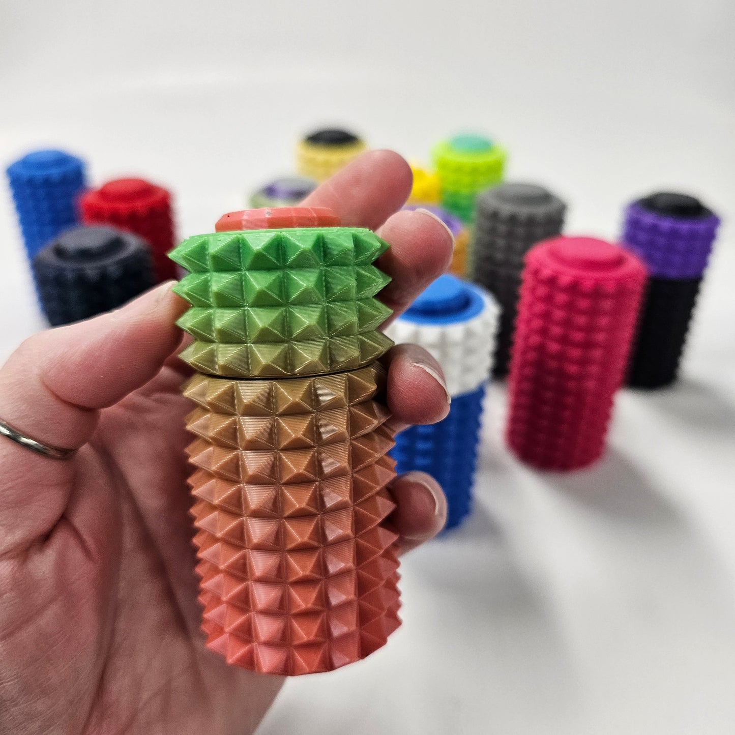 3d printed pain fidget spinner / clicker. Pink and green gradient colors. 