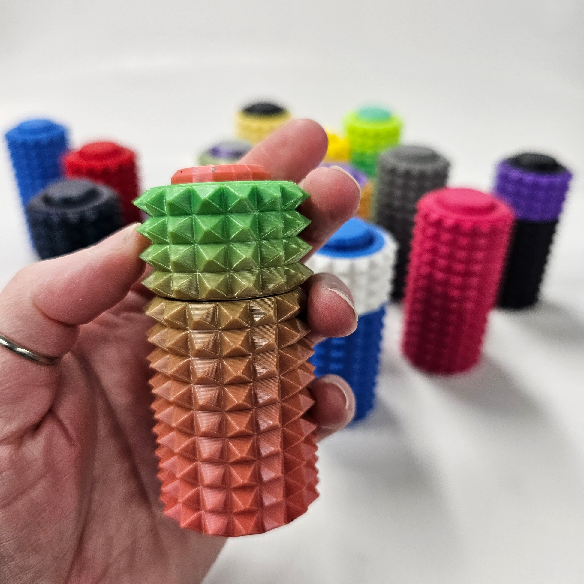 3d printed pain fidget spinner / clicker. Pink and green gradient colors. 