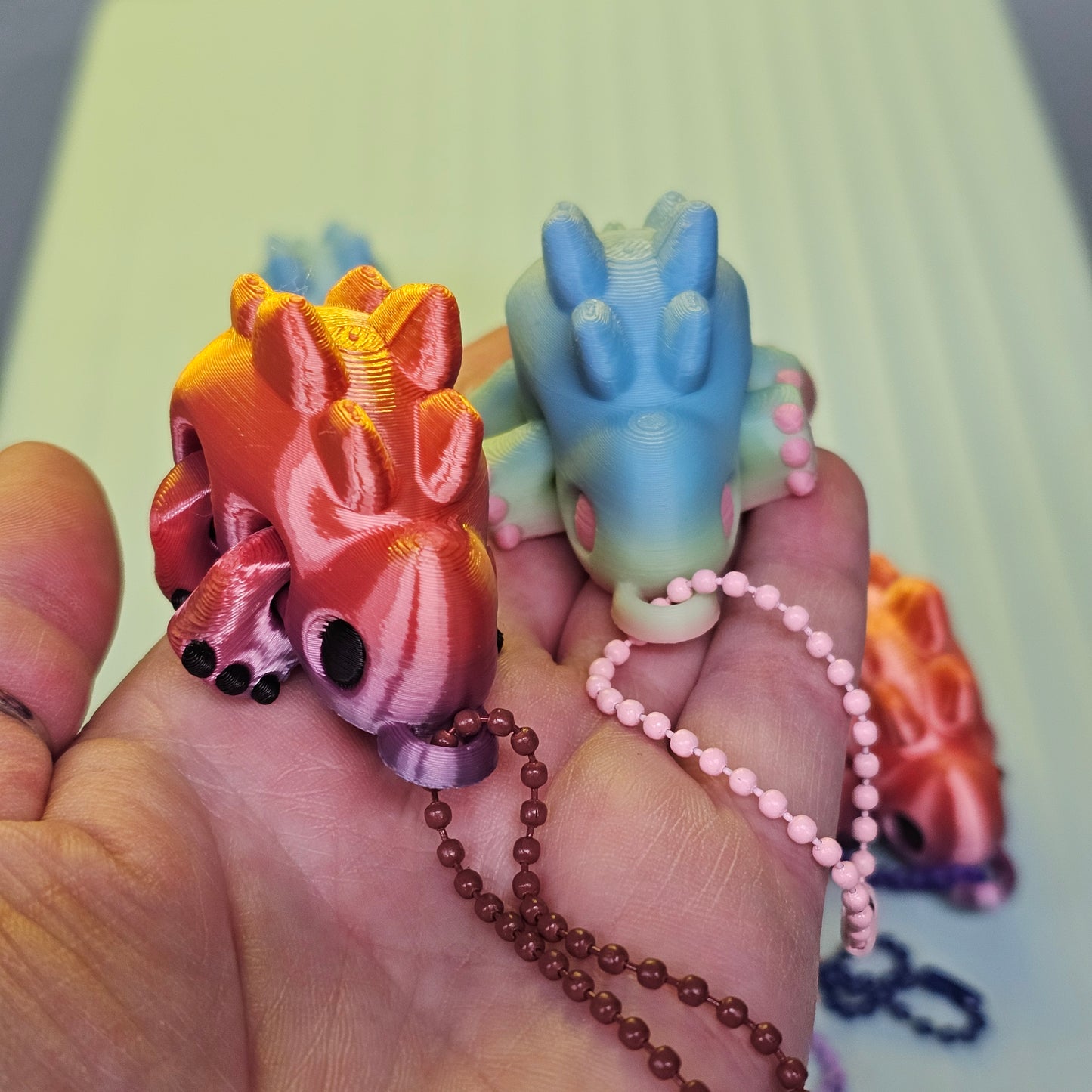 Colorful dinosaur-shaped keychains on a hand