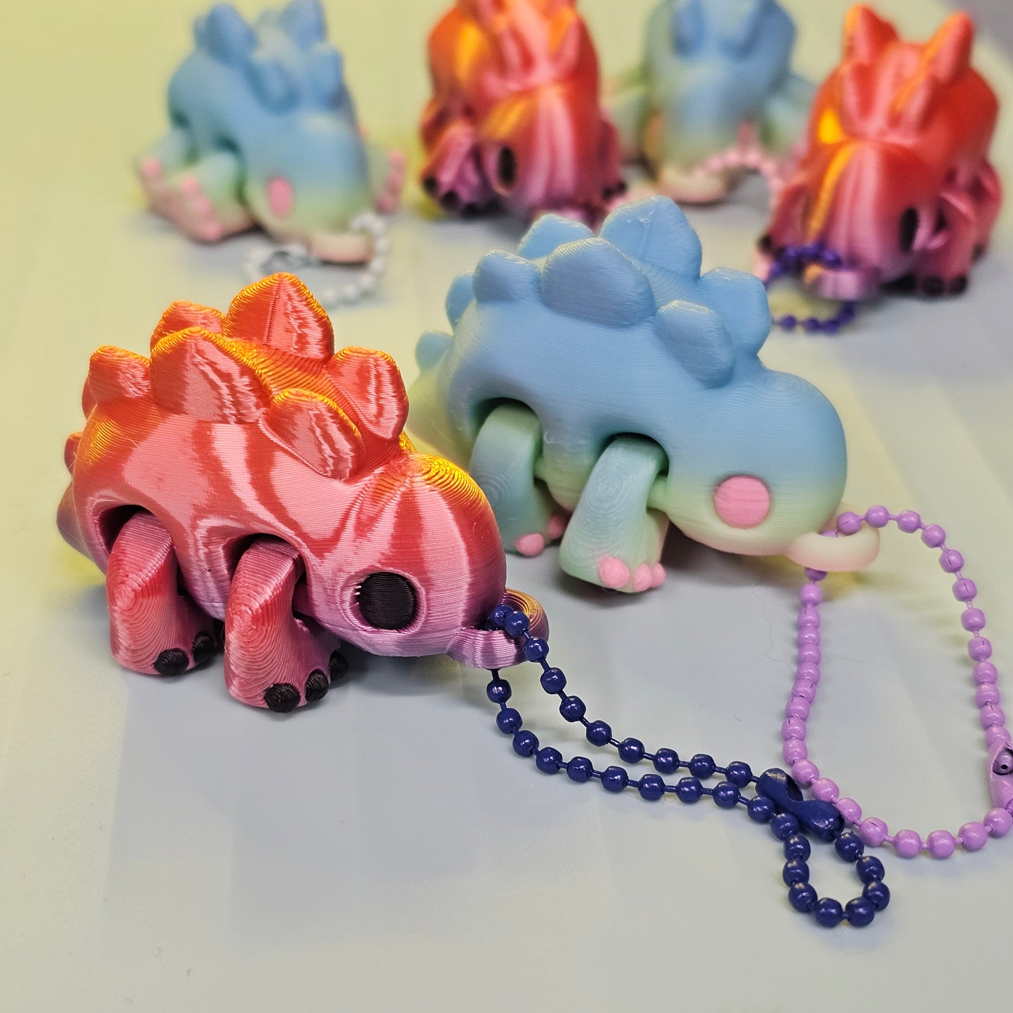 Colorful dinosaur-shaped keychains on a white background