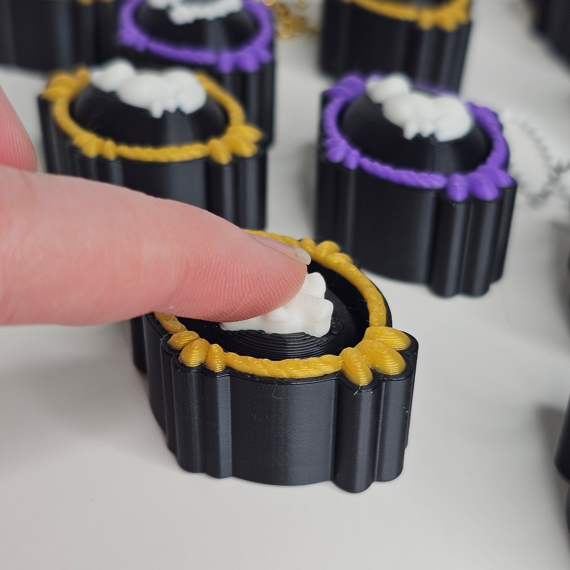 Purple and gold framed keychain clickers pushed down