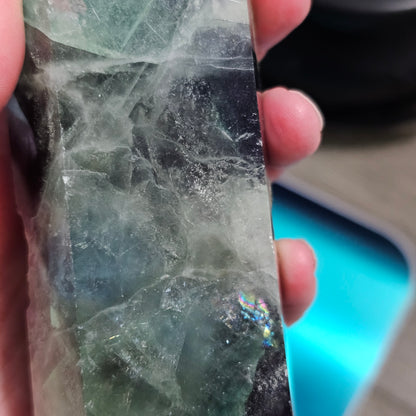 Close-up of a crystal held between fingers with a blurred background